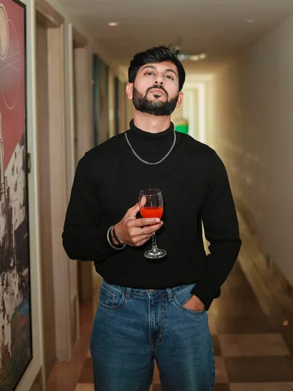 A sophisticated and moody shot in a black turtleneck. Holding a glass of wine, this portrait creates a story of class and style.