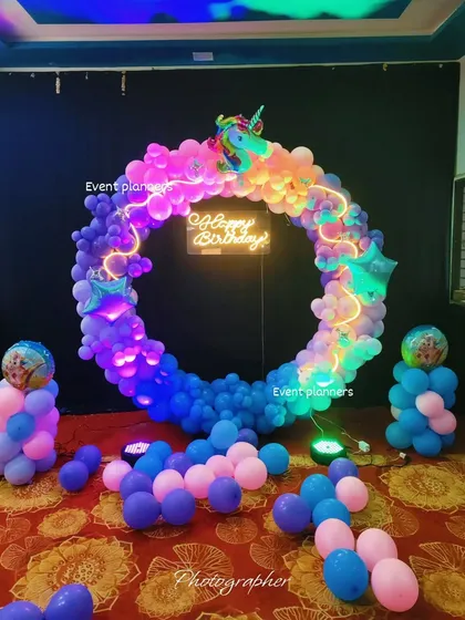 A rainbow-colored unicorn-themed balloon ring, perfect as a photo booth for a birthday party.