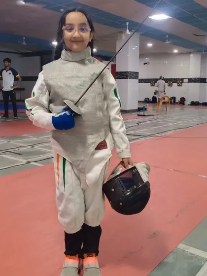 The proud look of a fencer. This is one of our young students, fully equipped and ready for action. Our camp is designed to instill a sense of discipline, confidence, and passion for the sport.