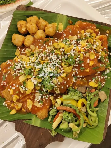 Our Chicken Crackers, served with butter-tossed veggies and fried potato bites. The presentation on a banana leaf adds a traditional touch to this modern dish.
