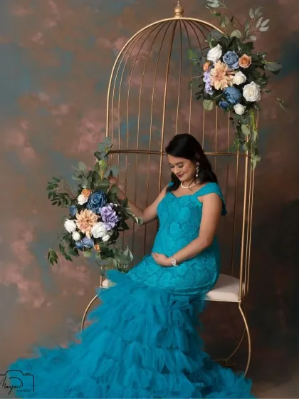 Seated gracefully in the golden cage, this mama-to-be cradles her bump, creating a serene and beautiful image of motherhood.