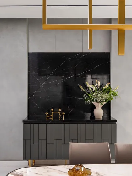 Detail of a custom-designed credenza in the 'ARR' project. The combination of a black marble backsplash, patterned grey cabinetry, and brass accents exemplifies our attention to bespoke details and material composition.