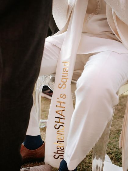 A custom stole for a member of the groom's squad, embroidered with 'ShahenSHAH's Squad'. A fun and personal touch for the wedding party.