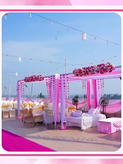 This outdoor seating area, or shamiyana, is decorated with pink and white drapes and floral accents, providing a comfortable and stylish space for guests to relax.