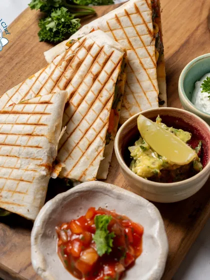 A full platter of my freshly grilled quesadillas, served with a trio of dips: salsa, guacamole, and sour cream. This is a perfect sharing platter for any informal gathering.