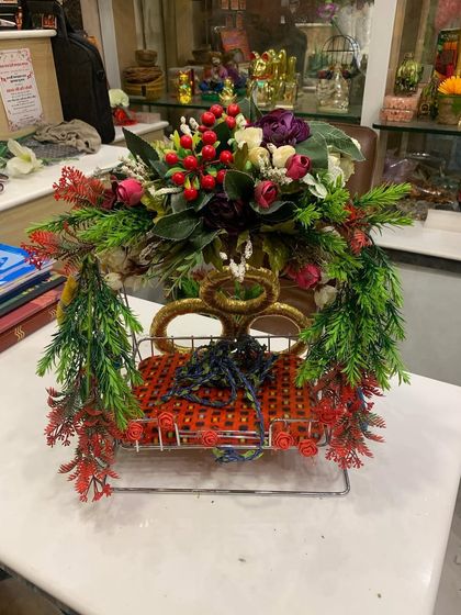 A decorated swing for a home temple, using artificial flowers and greenery. We provide various options for decorating your personal sacred space.