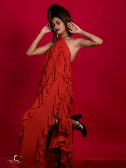 Another angle of the red gown, showing off the dramatic ruffles and the model's powerful stance.