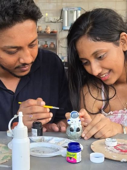 After the wheel, it's time for the details. This couple is focused on painting their small astronaut figurine, showing the variety of pieces you can make and decorate.