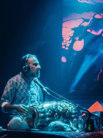 A beautiful shot of Pramath Kiran on stage, surrounded by lights and visuals. He is a true artist, painting with sound and rhythm.