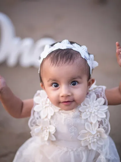 A close-up of this little beach baby, celebrating her first year. Her bright eyes and sweet expression are the focus of this milestone portrait.