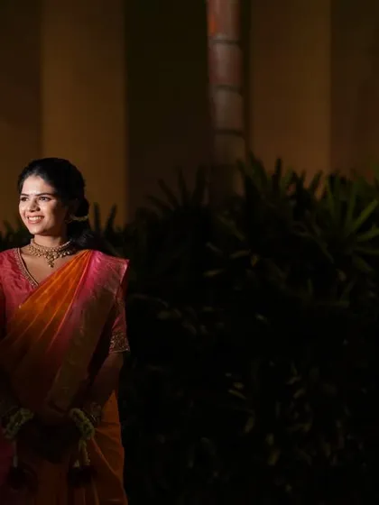 A wider portrait of the bride during her Haldi ceremony, set against a softly lit background. This shot captures the calm and happy ambiance of the pre-wedding ritual.