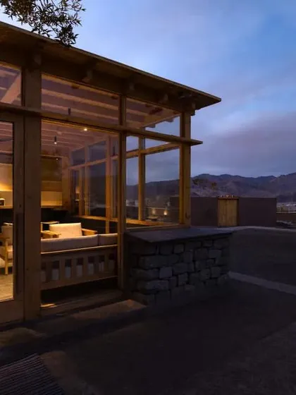 The guest rooms feature large windows that frame breathtaking views of the surrounding mountains, connecting visitors to the majestic scenery.