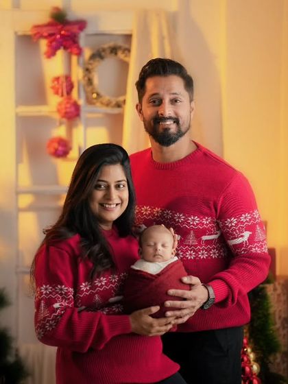 A classic family portrait with a newborn, with everyone in matching Christmas sweaters. I can help you coordinate outfits and props for a cohesive look.