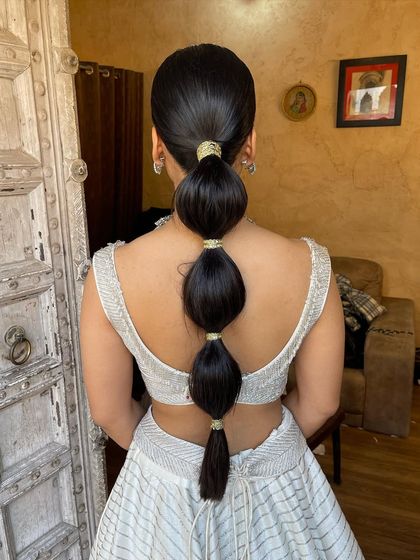 A sleek and modern bubble ponytail. This style is a fun and trendy choice for a Mehendi or cocktail party, and I've wrapped each section with gold thread for an extra touch of glam.