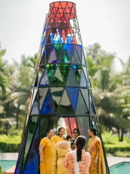 Guests taking photos inside the large Coachella tower, its colorful panels creating a beautiful stained-glass effect.