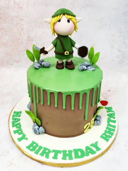 Another perspective of the Zelda cake, highlighting the drip effect and the small, rocky landscape details.