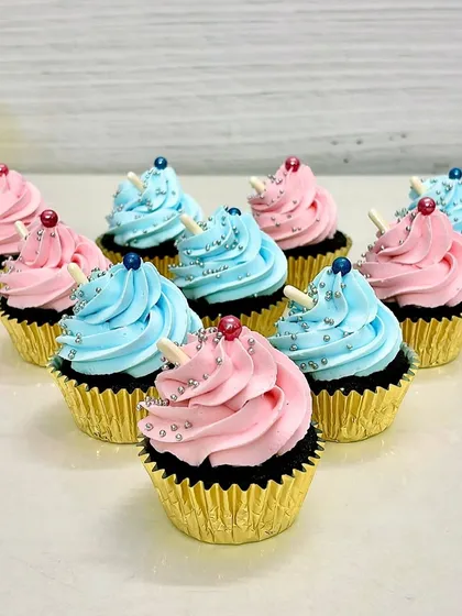 Classic pink and blue frosted cupcakes. Topped with silver sprinkles and a white chocolate stick, these are perfect for baby showers, gender reveals, or any colorful party.