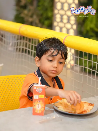 A close-up of a young boy enjoying his pizza and juice box. We have plenty of kid-approved options on our menu.
