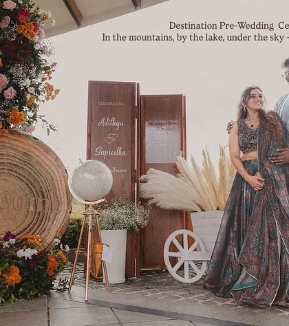 We love planning pre-wedding celebrations at stunning destinations like Wayanad. Here, the couple poses against a rustic-chic decor setup we created, with the mountains and lake providing a spectacular natural backdrop.