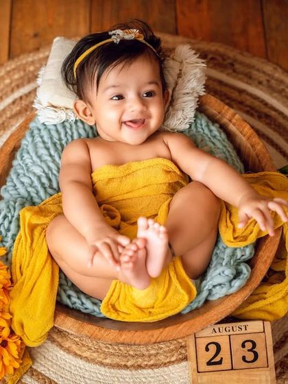 A happy baby in a basket. The warm yellow tones and rustic jute rug create a beautiful, earthy feel for this newborn session.