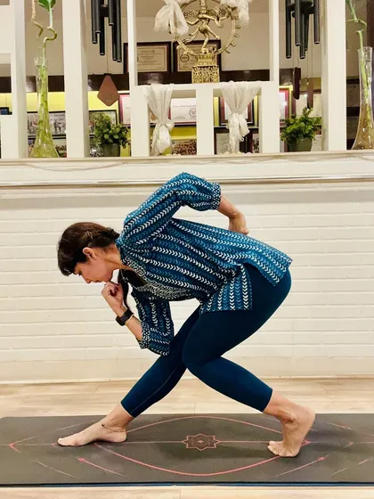 "Yoga is skill in action." This twisted lunge pose, performed in traditional attire, is a testament to how yoga is woven into the fabric of Indian life. It is a practice that is grounded, powerful, and timeless.