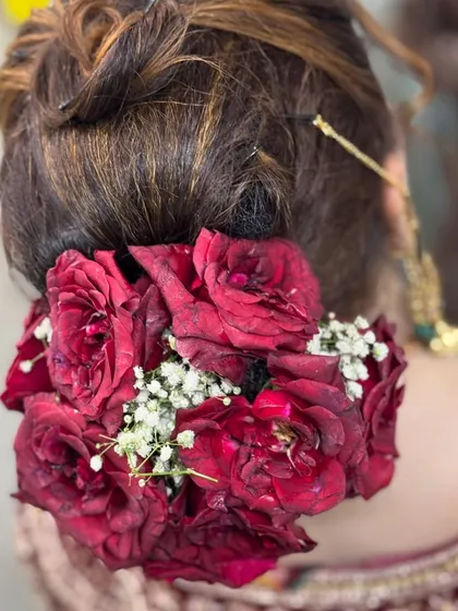 A bridal hairstyle needs to be both beautiful and secure. This is a classic floral bun I created for a Nikkah bride, using fresh red roses and baby's breath to create a timeless and romantic look that perfectly held her dupatta.