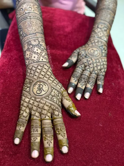 This engagement design features the initial 'R' in a lovely circular frame, with intricate net patterns covering the fingers and palm.