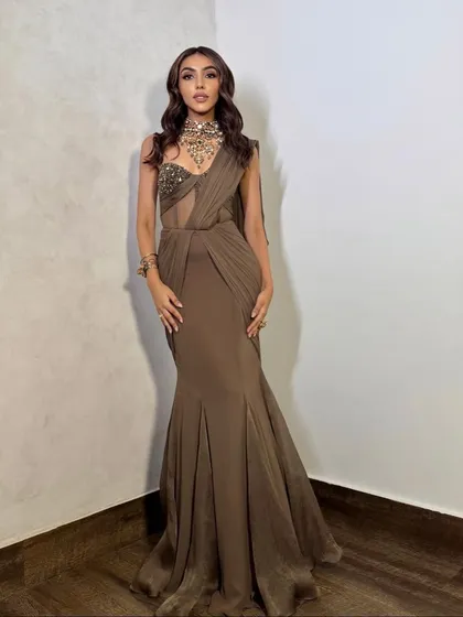A full-length shot of this gorgeous editorial look. The neutral-toned makeup with smoky eyes allows the unique silhouette of the gown and the statement necklace to shine.