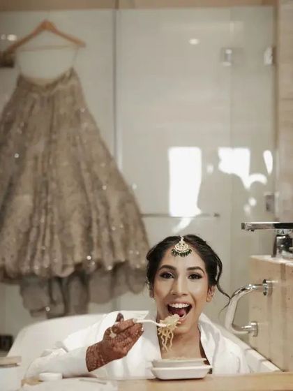 A fun and real moment. The bride enjoys a quick meal in the bathtub before the ceremony, her dress hanging in the background. It's these unscripted moments I love.