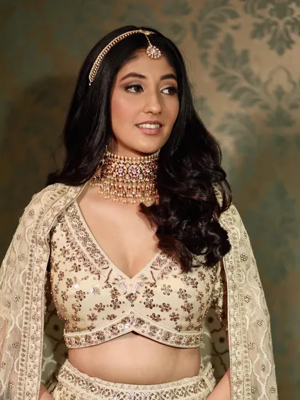 A close-up of Pooja's modern bridal look. The focus is on a flawless, radiant base and soft, neutral tones that enhance her features without overpowering them.