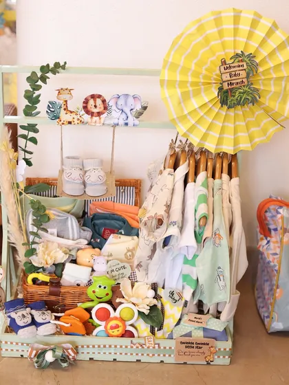 This was part of a jungle-themed baby wardrobe hamper. I used a mini clothing rack to display adorable onesies and filled the basket below with rattles, shoes, and soft toys.