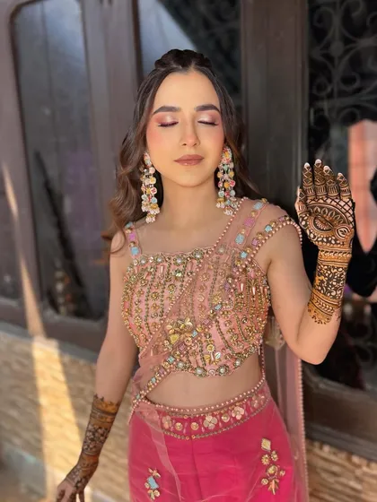 A close-up of the Mehndi look with eyes closed, showing the beautiful shimmer on the lids and the intricate henna design.
