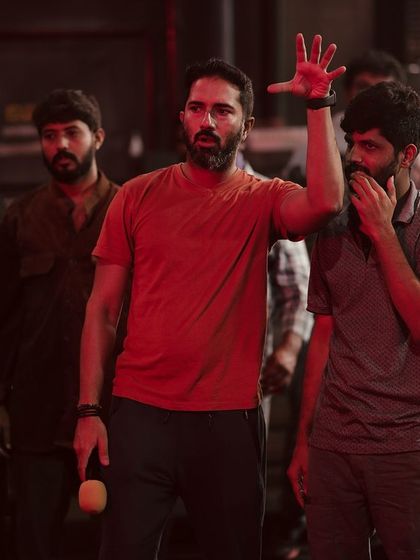 Explaining the blocking for a large group fight scene. Clear communication is critical when you have dozens of stunt performers moving at once. Every action is carefully choreographed for maximum impact and safety.