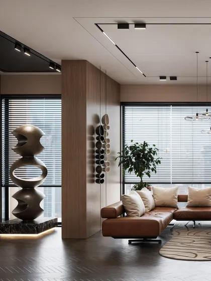 A waiting area for an office, featuring a comfortable leather sofa and a large sculptural art piece.