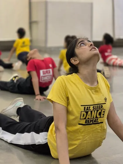 Conditioning the body is just as important as learning the steps. Here, students are doing stretches and warm-ups to prepare for an intense dance session.