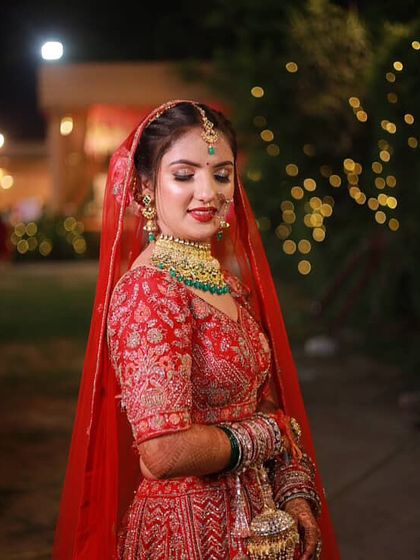 A beautiful candid shot of my bride. The soft lighting highlights her glowing skin and the intricate details of her red lehenga.