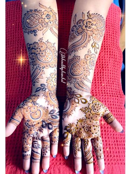 A gorgeous Arabic-style mehendi with bold, flowing paisley and floral patterns. The use of negative space makes the design pop.