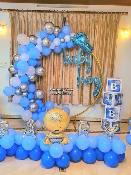 A 'Welcome Baby Boy' decoration for a home celebration. This setup includes a circular balloon arch, 'BABY' blocks, and foil balloons.