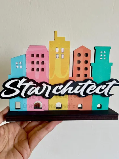 Holding the 'Starchitect' standee to give a sense of its size. It's a sturdy and eye-catching desk accessory.