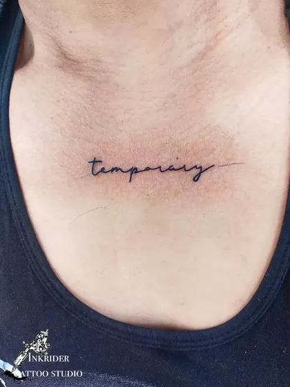 The word 'temporary' inked on the chest. This tattoo serves as a powerful reminder of the transient nature of things, good or bad.