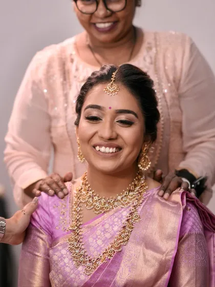 A happy moment with the bride and her Aai. The bride's makeup is flawless as she shares a smile, surrounded by love.