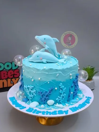 An underwater-themed cake with two sweet dolphins playing in the waves, decorated with gelatin bubbles.