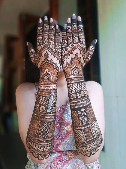 A full-arm bridal design with beautiful arch patterns on the palms and dense, intricate work covering the arms.