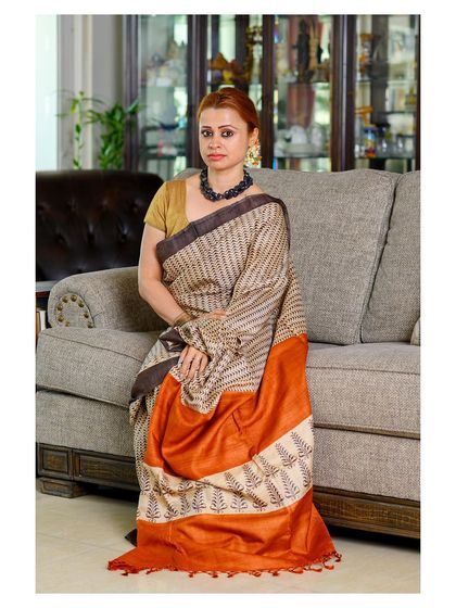 A seated pose that showcases the saree in a relaxed, elegant manner. Lifestyle shots like this help customers connect with the brand.