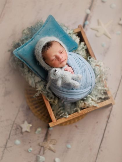 The beginning of life. This dreamy blue setup in a wooden box, complete with a tiny pillow and teddy, is perfect for a sleeping baby boy.