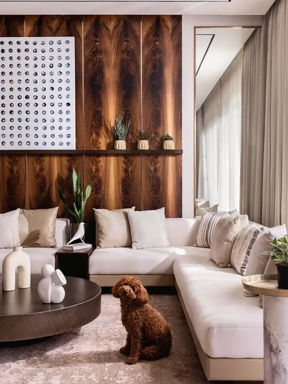 For our "Coffee, with a dash of Cream" project, we created a living space that exudes quiet luxury. The combination of a plush cream sofa, rich mahogany wall paneling, and curated art creates a warm, sophisticated environment. Even the family pet finds its perfect spot in this comfortable and stylish room.