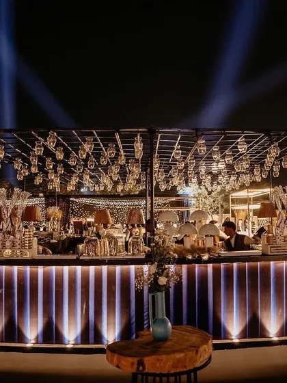 The bar is always a key feature. For this event, we created a stunning illuminated bar with an overhead structure holding dozens of hanging lamps, ensuring it was a beacon of light and activity all night long.