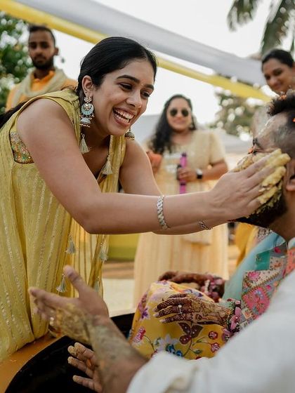 A guest playfully applies Haldi paste to the groom, a quintessential and fun-filled moment of the ceremony.