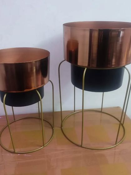 I love this two-tone planter set. It features a copper-finish pot that sits inside a black metal base with a gold stand, creating a chic, layered look that is very on-trend.