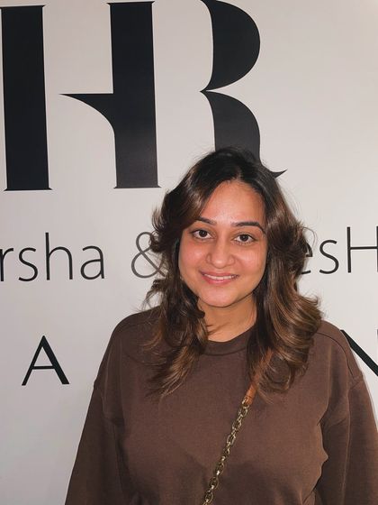 The client is thrilled with her new look, showcasing the beautiful color and style against our salon's logo.